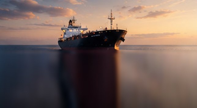 Oil and fuel tanker sailing at sunset